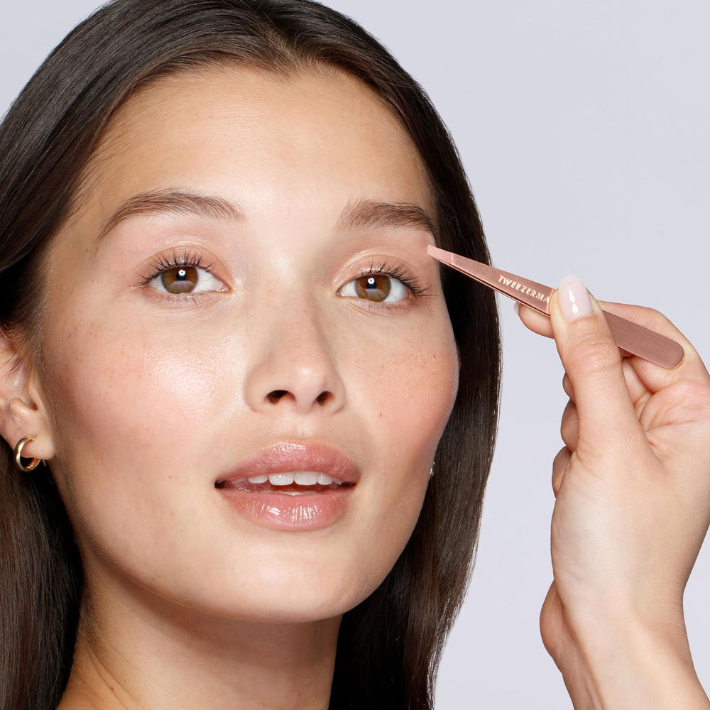 Tweezerman rose gold petite tips close-up—hand-filed precision grabs every hair.