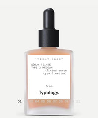 Typology tinted serum bottle close-up promoting radiant skin with vegan formula.