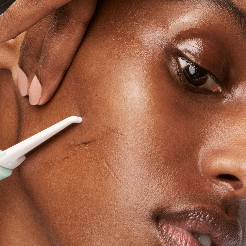 Versed Instant Gratification dermaplaning tool close-up reveals fresh, smooth skin surface.