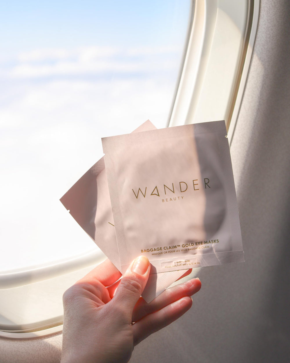 Wander Beauty Baggage Claim rose-gold-foil patches on skin during use.