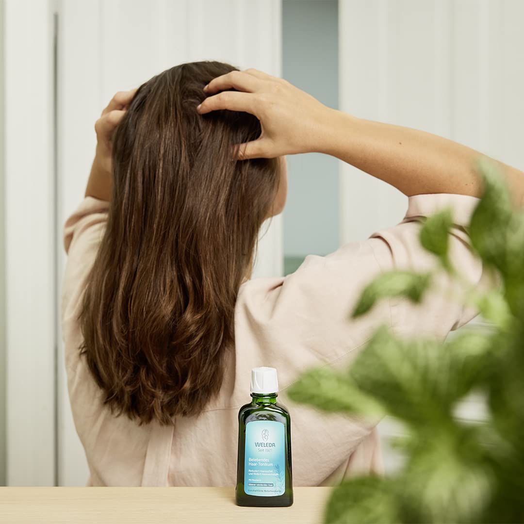 Weleda Rosemary Conditioning Hair Oil bottle beside glossy hair result