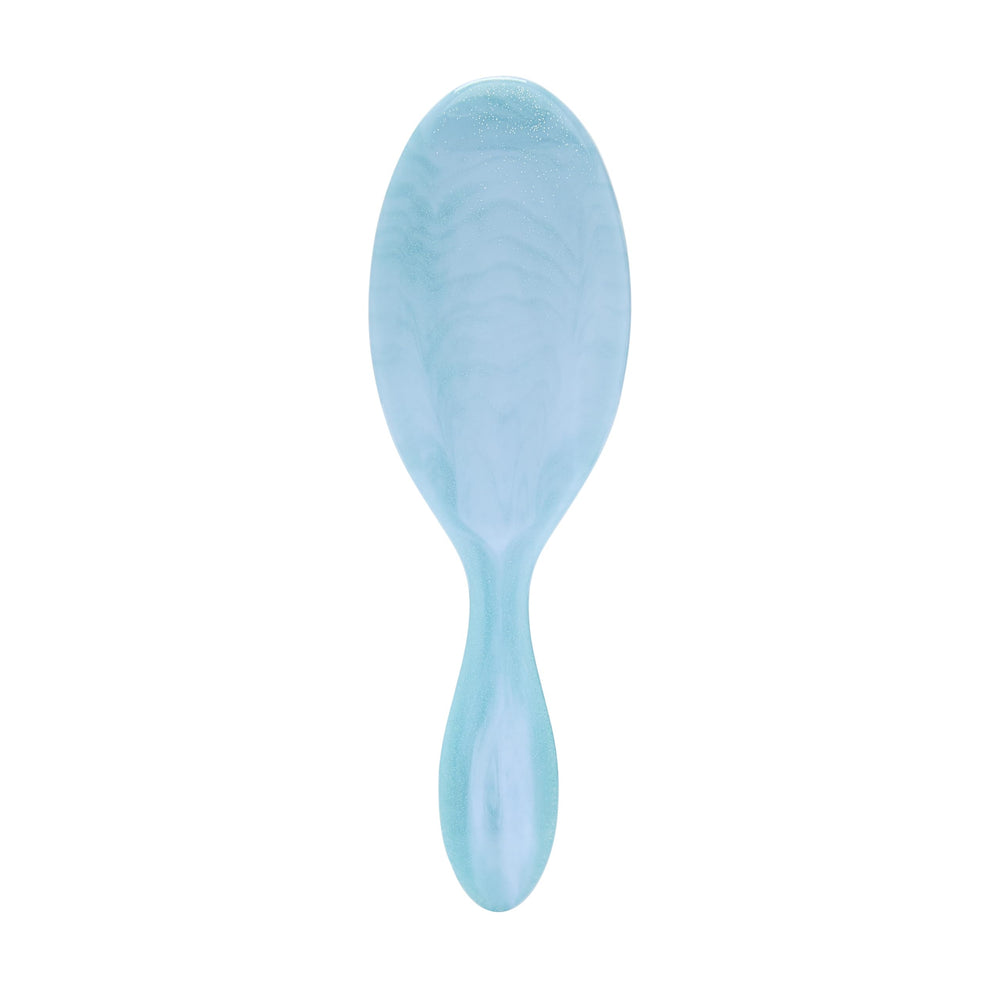 Wet Brush Original Detangler close-up on blue glitter waves for gentle detangling on wet and dry hair.