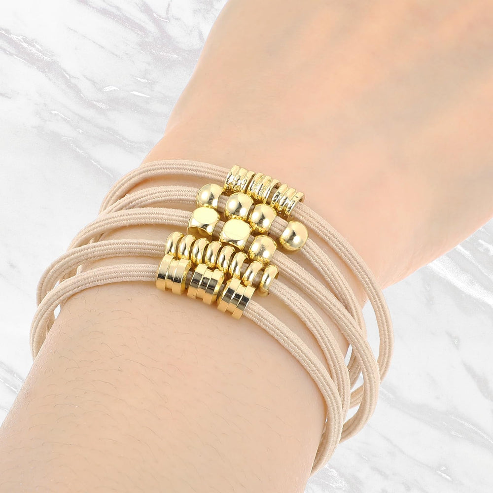 WY LIGHTING LEVEL gold-plated hair tie adds secure hold and radiance