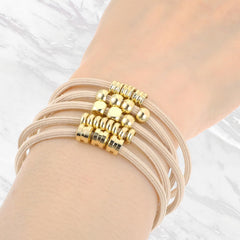 WY LIGHTING LEVEL gold-plated hair tie adds secure hold and radiance