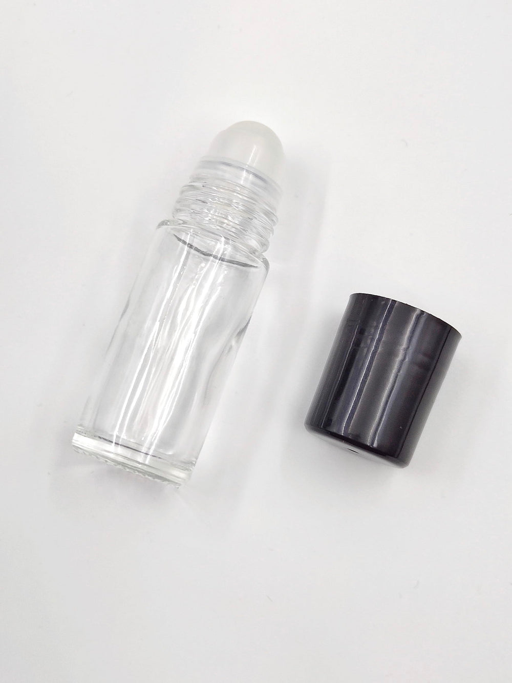 YYNGJCK clear glass roller bottle detail emphasizing corrosion resistance and purity.